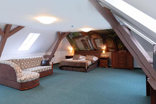 a attic bedroom with two beds and a couch at Hotel Polonia - Frankfurt/Oder in Frankfurt/Oder