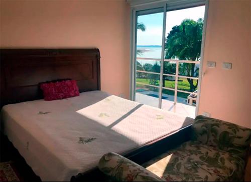Schlafzimmer mit einem Bett und einem Fenster mit Aussicht in der Unterkunft Casa em Avaré ao lado da Represa do Jurumirim in Palmeiras