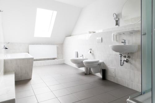 a white bathroom with a sink and a toilet at Hotel Polonia - Frankfurt/Oder in Frankfurt/Oder