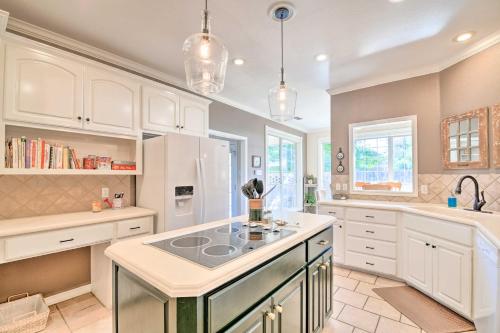 a kitchen with white cabinets and a stove top island at Abilene Home with Backyard and Grill Walk to ACU in Abilene