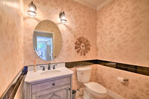 a bathroom with a toilet and a sink and a mirror at Abilene Home with Backyard and Grill Walk to ACU in Abilene