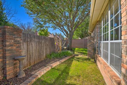 a backyard with a brick fence and a garden at Abilene Home with Backyard and Grill Walk to ACU in Abilene