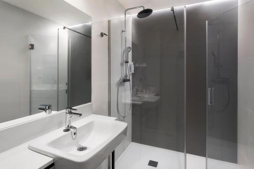 a bathroom with a sink and a glass shower at B&B HOTEL Málaga Centro in Málaga