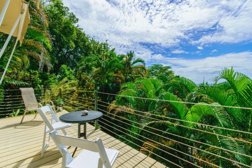 a balcony with a table and two chairs and trees at Funky Monkey Lodge in Santa Teresa Beach