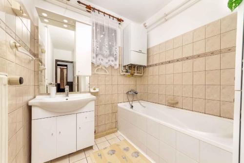 ein weißes Badezimmer mit einem Waschbecken, einer Badewanne und einem Waschbecken in der Unterkunft Holiday home in Balatonkeresztur 19529 in Balatonmáriafürdő