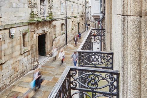 a group of people walking down a street on a balcony at Apartamentos Orfas in Santiago de Compostela