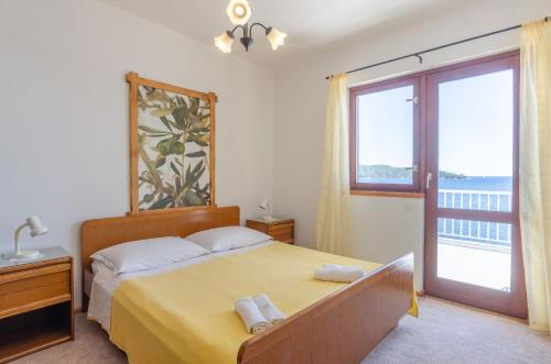 a bedroom with a bed with a view of the ocean at Apartmani Srdjana in Prizba