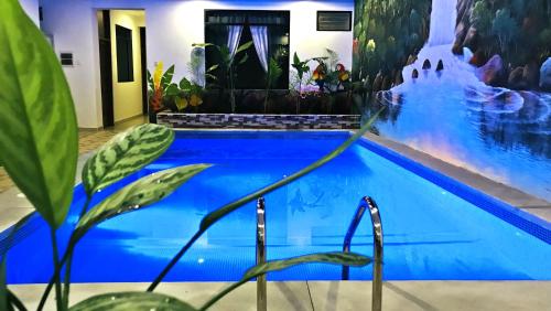 a blue swimming pool with a painting on the wall at Residencial Lago Verde in Tarapoto