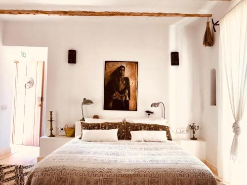a bedroom with a large bed with a painting on the wall at Dar Alya Essaouira Maison et table d'hôtes in Ghazoua