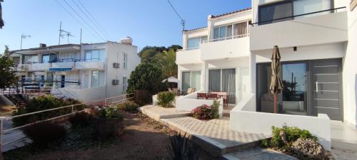a white house with a patio and a building at Mediterranean Seaside Authentic Beach House in Polis Chrysochous