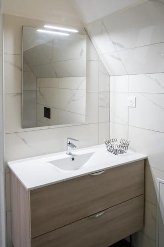 a bathroom with a sink and a mirror at Les Gîtes d'Halatte in Fleurines