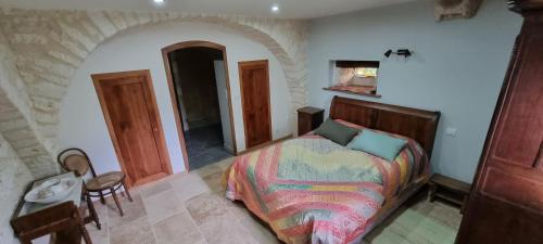 a bedroom with a bed and a table and a chair at Ferme de Laspeyrières in Montcuq