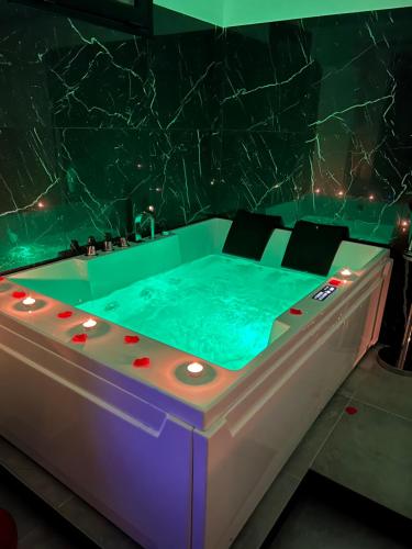 a jacuzzi tub in a room with a marble wall at Real suite spa in Palermo