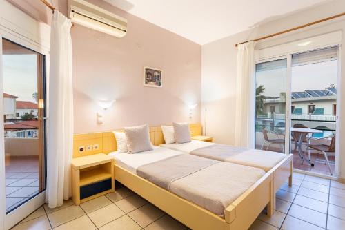 a bedroom with a bed and a balcony at Anna Αpartments II in Agia Marina Nea Kydonias