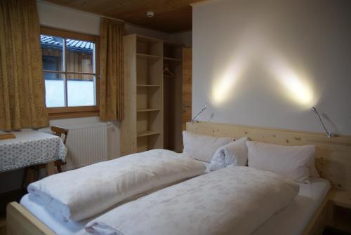 a bedroom with two beds and a window at Gästehaus Obererlacher in Obertilliach