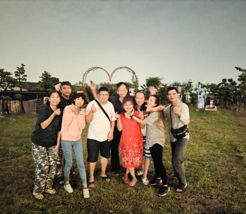 a group of people posing for a picture in a field at Xinyuanbao Shangshi Homestay in Donggang