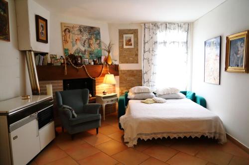 ein Schlafzimmer mit einem Bett, einem Stuhl und einem Schreibtisch in der Unterkunft Re Piano appartamento Le Rondini in Modigliana
