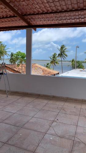 a balcony with a view of the ocean and palm trees at Pousadinha da Lulu - Pontal Mangue Seco in Indiaroba