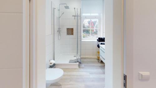 a bathroom with a shower and a toilet and a sink at Lieblingsapartment No.3 mit 2 Schlafzimmern in Top City-Lage in Rostock