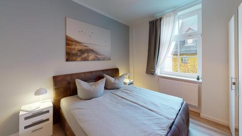 a bedroom with a bed with blue sheets and a window at Lieblingsapartment No.3 mit 2 Schlafzimmern in Top City-Lage in Rostock