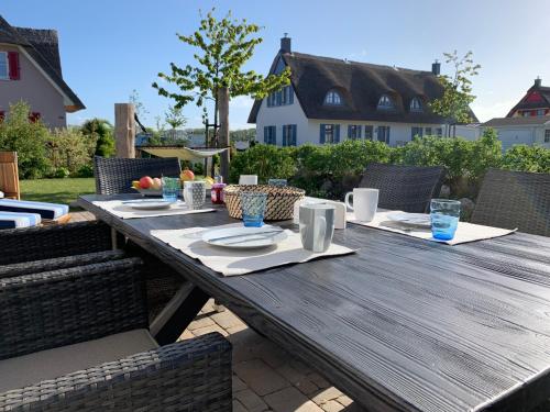 een houten tafel met borden eten op een patio bij Emilias Hüs, Reethaus in der Bucht von Wismar in Zierow