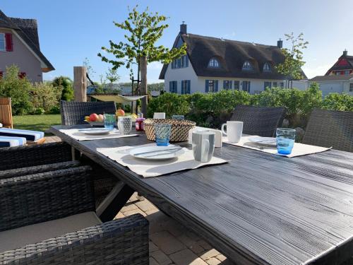 a wooden table with plates of food on a patio at Emilias Hüs, Reethaus in der Bucht von Wismar in Zierow