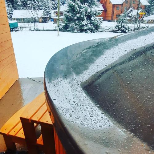 a table with water on top of it with a bench at Сімейний номер 1 Садиба У Ані in Synevyrsʼka Polyana