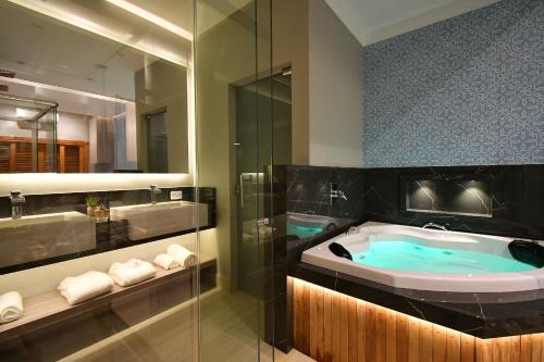 a bathroom with a bath tub and a shower at Pousada Chão de Folhas SPA Boutique in Águas de Lindóia