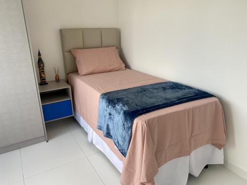 een kleine slaapkamer met een bed met een deken erop bij Dona Olivia Residencial in Vitória da Conquista