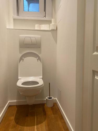 a white toilet in a bathroom with a window at Ruim appartement gelegen te centrum Knokke in Knokke-Heist