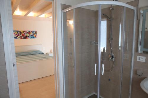 una doccia con porta in vetro in bagno di B&B ARCOBALENO a Cittanova