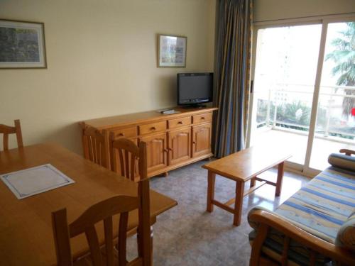 a living room with a dining table and a television at Apartamentos Palas Salou in Salou