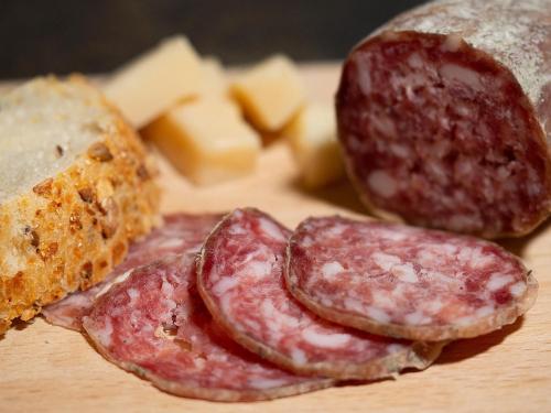 a group of salami and cheese on a cutting board at Al Fogolâr Rooms & Osteria with Saunaland in Tolmezzo
