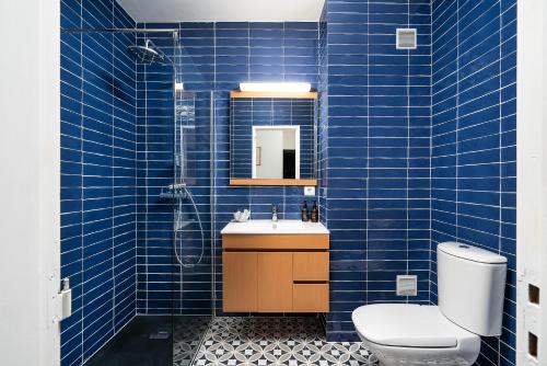 bagno piastrellato blu con servizi igienici e lavandino di stylish apartment with marina view and aircon a Portimão