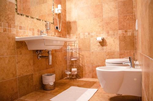 a bathroom with a white toilet and a sink at Al Fogolâr Rooms & Osteria with Saunaland in Tolmezzo