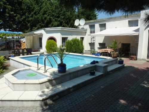 a swimming pool in front of a house at Pension Münch "Am Anger" in Neuseußlitz