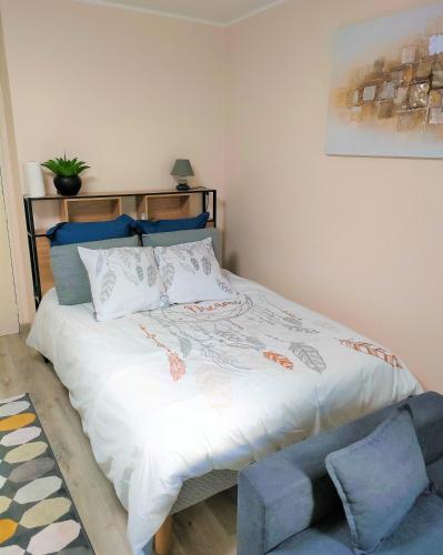 une chambre avec un lit et une chaise bleue dans l'établissement Lovely flat nearby Paris fully redone with free parking on premises and balcony, à Clichy