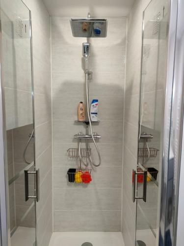 une salle de bain avec une douche avec une porte vitrée dans l'établissement Lovely flat nearby Paris fully redone with free parking on premises and balcony, à Clichy