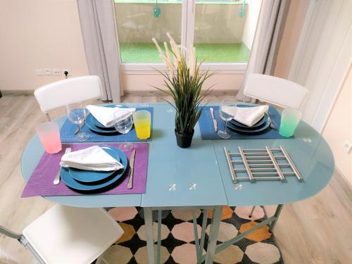 a blue table with plates and glasses on it at Lovely flat nearby Paris fully redone with free parking on premises and balcony in Clichy