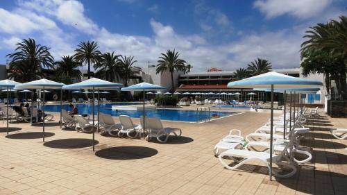 a group of chairs and umbrellas next to a pool at South Tenerife 471 in Costa Del Silencio