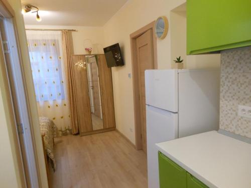 une cuisine avec un réfrigérateur blanc et un couloir dans l'établissement Ţestoasa Montana Sinaia, à Sinaia