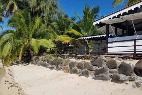 a resort with palm trees and a sandy beach at Villa Iris in Pihaena