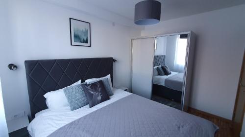 um quarto com uma cama grande e um espelho em Relax apartment Koaponik em Kopaonik