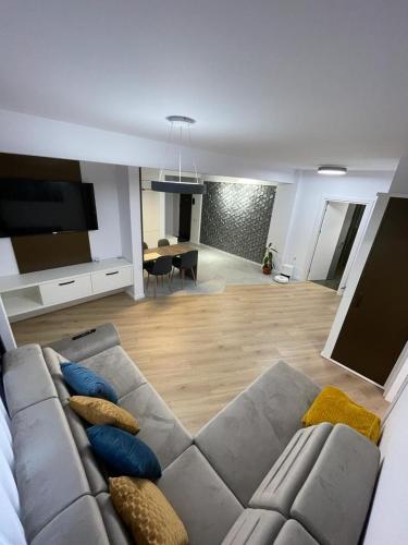 een woonkamer met een bank met kussens erop bij Adina Apartament in Gura Humorului