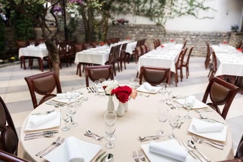 a table set up for a wedding with wine glasses and roses at Hotel Afa in Pristina
