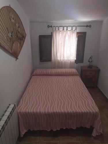 1 dormitorio con 1 cama con colcha de color naranja en La Cañada, en Yeste