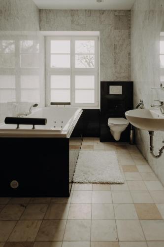 a bathroom with a tub and a toilet and a sink at Pałac Bogaczów - noclegi - restauracja - przyjęcia in Bogaczów