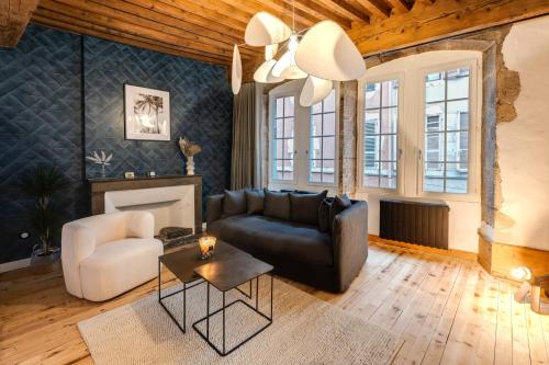 un salon avec un canapé en cuir noir et une cheminée dans l'établissement L'Appart' - Ideal for a stay in the city center near the Lake, à Annecy