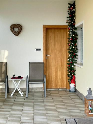 a room with a christmas tree and a door at Casa Roberto - piano terra con giardino in Levico Terme