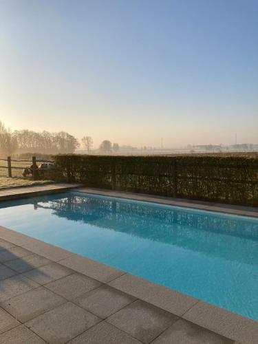 a swimming pool in a yard with a fence at Maison mystique in Staden